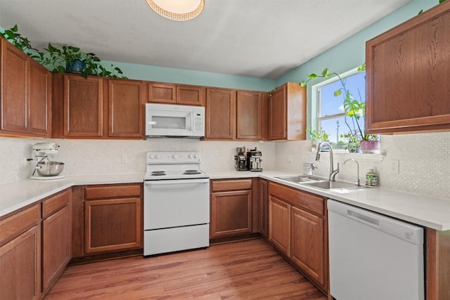 12833 Carillon Way, Manor, TX 78653 - kitchen featuring white appliances, a sink, tasteful backsplash, light wood-style flooring, and light countertops