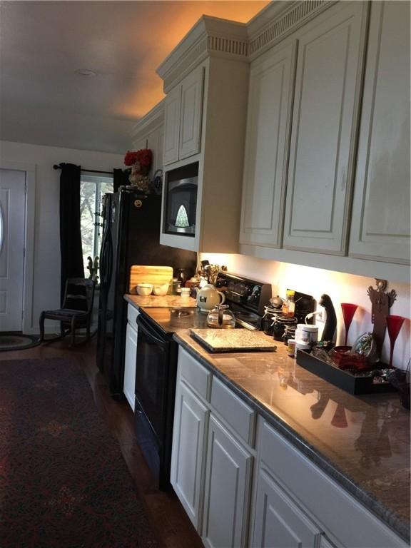 156 Lazy Leaf Ln, Wimberley, TX 78676 - kitchen featuring black range with electric cooktop, white cabinets, and dark wood finished floors