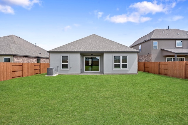 rear view of property with central AC unit, ceiling fan, a fenced backyard, and a lawn