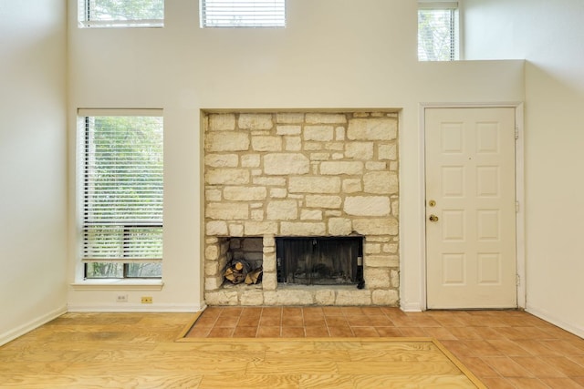 unfurnished living room with baseboards, a high ceiling, and plenty of natural light