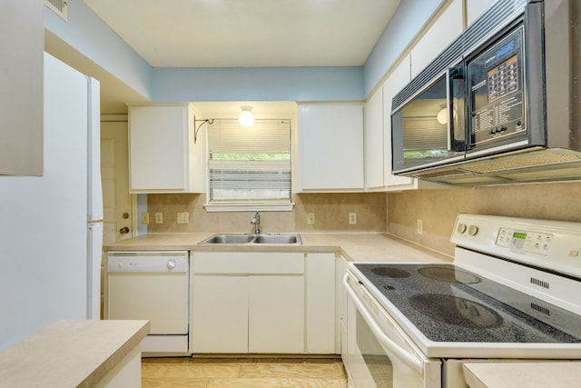 kitchen featuring visible vents, white appliances, light countertops, and a sink