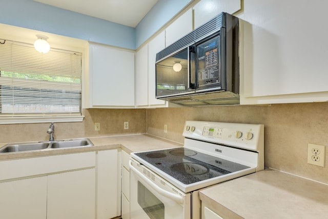 kitchen featuring a sink, black microwave, light countertops, white range with electric cooktop, and white cabinets