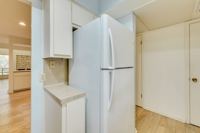 kitchen with light wood finished floors, recessed lighting, white cabinetry, light countertops, and freestanding refrigerator