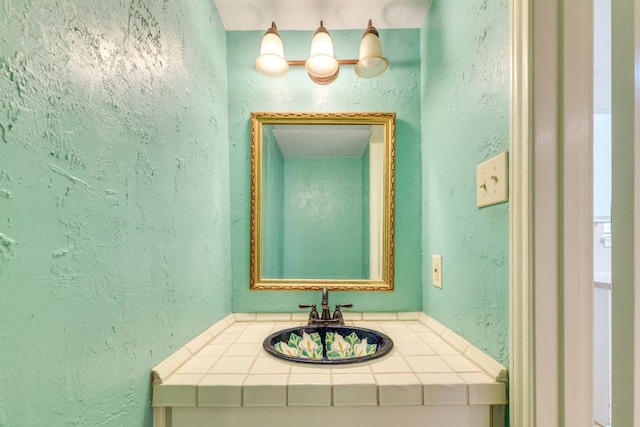 bathroom with a textured wall and vanity