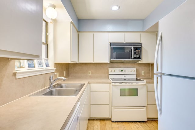 9226 Jollyville Rd Unit 132, Austin, TX 78759 - kitchen featuring white appliances, a sink, light countertops, light wood-style flooring, and backsplash
