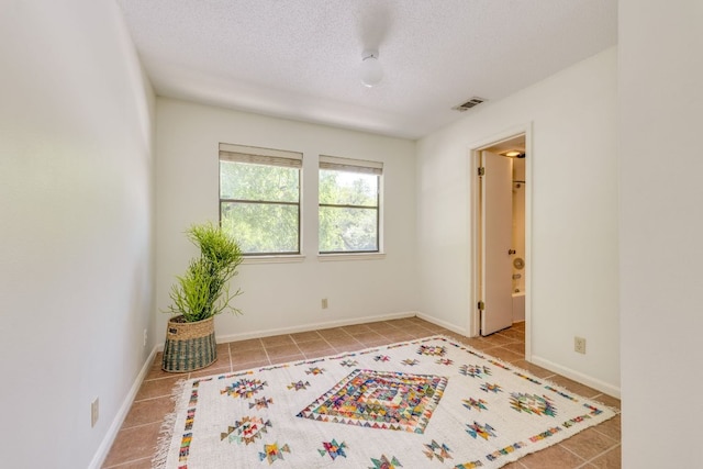 9226 Jollyville Rd Unit 132, Austin, TX 78759 - spare room featuring tile patterned flooring, a textured ceiling, and baseboards