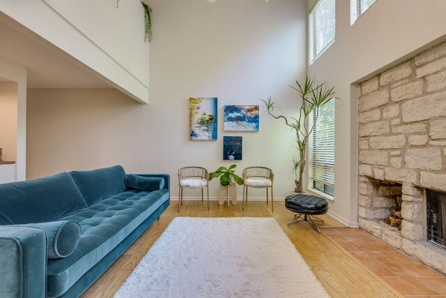 9226 Jollyville Rd Unit 132, Austin, TX 78759 - living room featuring a stone fireplace, a high ceiling, and wood finished floors