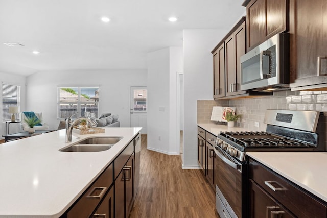 185 Silver Springs Bnd, Kyle, TX 78640 - kitchen with a sink, light countertops, stainless steel appliances, and dark wood finished floors