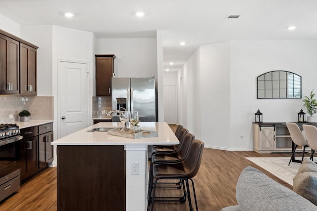185 Silver Springs Bnd, Kyle, TX 78640 - kitchen with appliances with stainless steel finishes, a sink, a kitchen island with sink, light countertops, and decorative backsplash