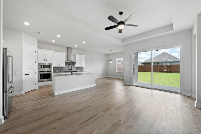 unfurnished living room with visible vents, recessed lighting, light wood-style flooring, a ceiling fan, and baseboards