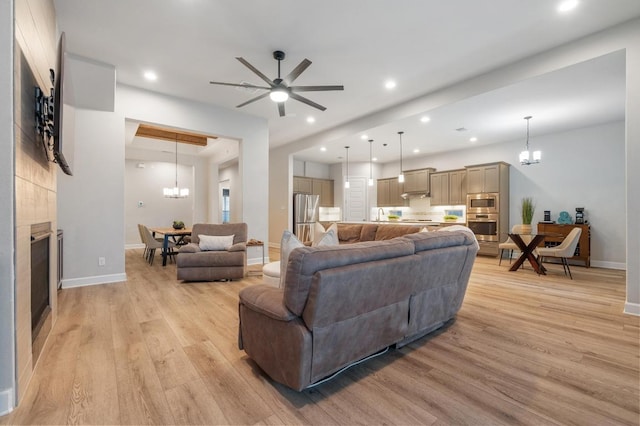 living area featuring baseboards, light wood finished floors, recessed lighting, and a fireplace