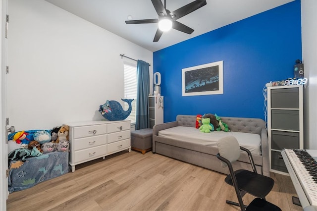 bedroom with a ceiling fan and light wood-style floors