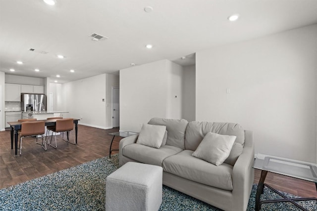 living area featuring recessed lighting, visible vents, and dark wood finished floors
