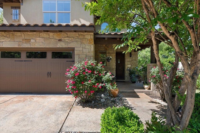 exterior space featuring stone siding, stucco siding, and a garage