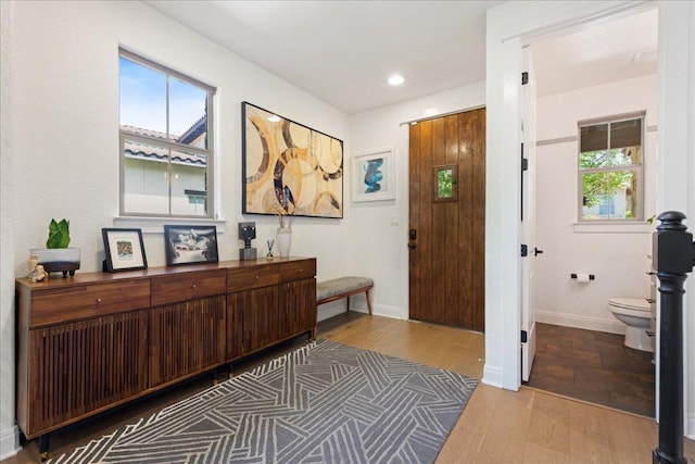 entryway with plenty of natural light, recessed lighting, wood finished floors, and baseboards