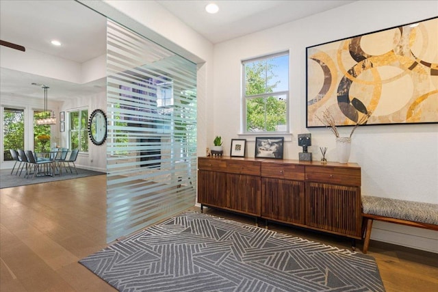 corridor featuring wood finished floors and recessed lighting