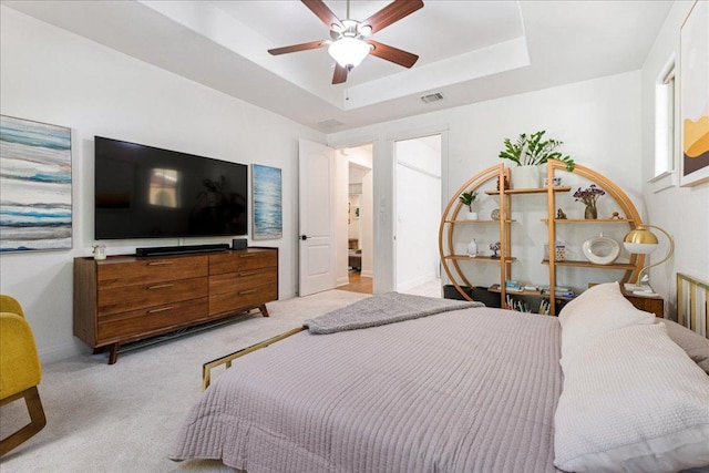 15213 Falconhead Grove Loop, Austin, TX 78738 - bedroom with light carpet, a tray ceiling, and a ceiling fan