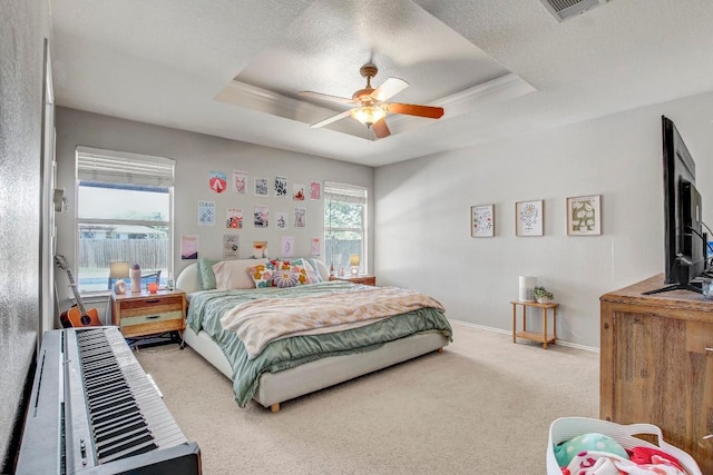 bedroom with ceiling fan, carpet floors, a raised ceiling, baseboards, and visible vents