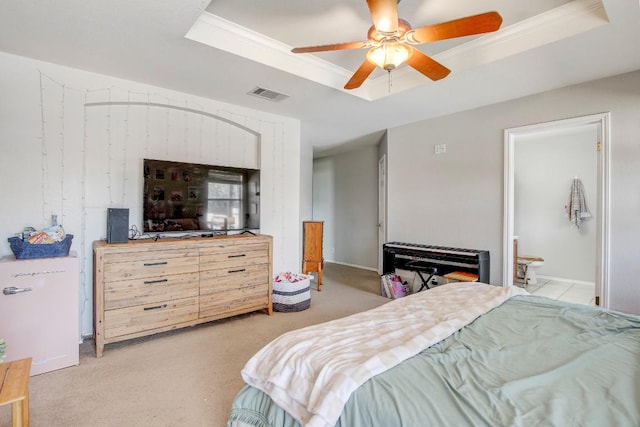 bedroom with a tray ceiling, visible vents, light colored carpet, a ceiling fan, and connected bathroom