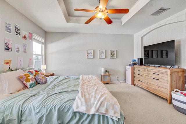 bedroom featuring a raised ceiling, visible vents, a ceiling fan, and light colored carpet