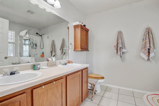 bathroom with tile patterned floors, visible vents, a sink, and a shower stall