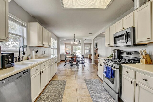 kitchen featuring a sink, light tile patterned flooring, a chandelier, light countertops, and appliances with stainless steel finishes