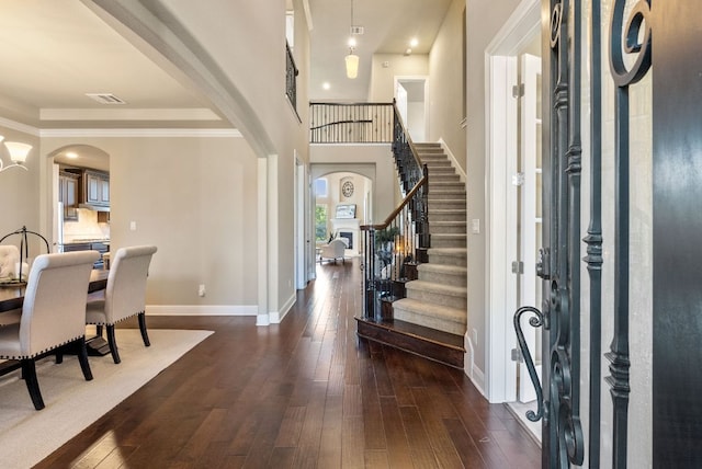 3817 Benetton Way, Leander, TX 78641 - entryway featuring arched walkways, dark wood-type flooring, baseboards, and stairway