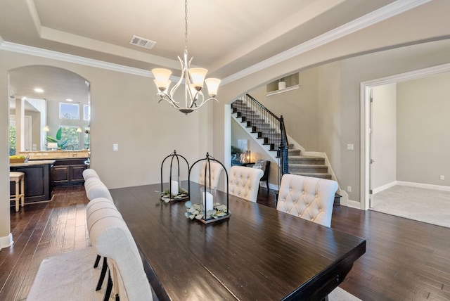 3817 Benetton Way, Leander, TX 78641 - dining room with arched walkways, stairway, dark wood finished floors, a tray ceiling, and crown molding