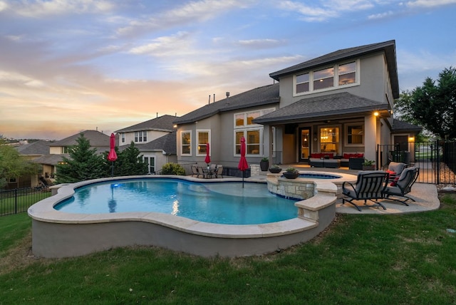 3817 Benetton Way, Leander, TX 78641 - back of house at dusk with stucco siding, an outdoor hangout area, a patio area, roof with shingles, and a pool with connected hot tub