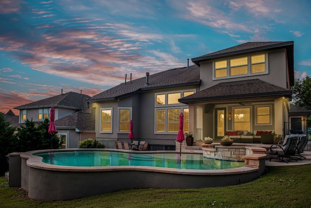 3817 Benetton Way, Leander, TX 78641 - back of house at dusk with outdoor lounge area, stucco siding, an outdoor pool, and a patio area