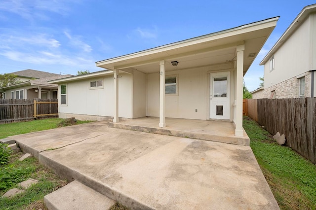back of property with a patio area and a fenced backyard