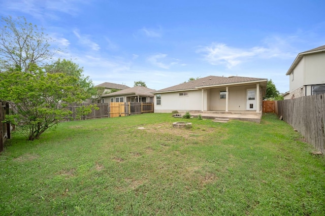 view of yard featuring a patio, a fenced backyard, and a fire pit