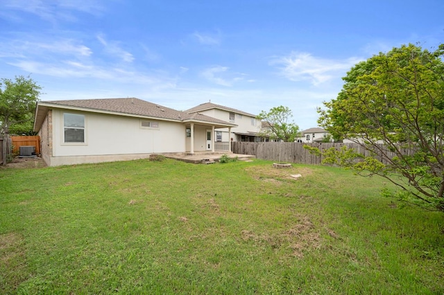 back of house with central AC unit, a fenced backyard, a patio, and a yard