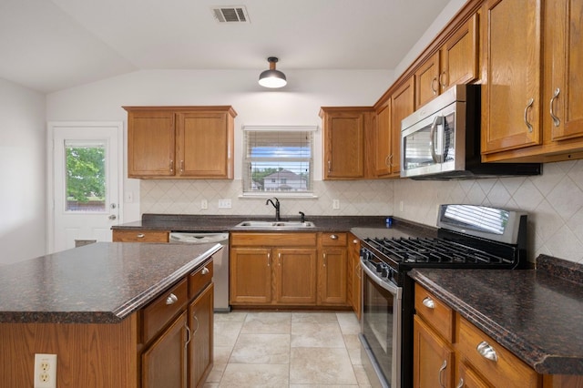 kitchen featuring brown cabinets, appliances with stainless steel finishes, and a sink