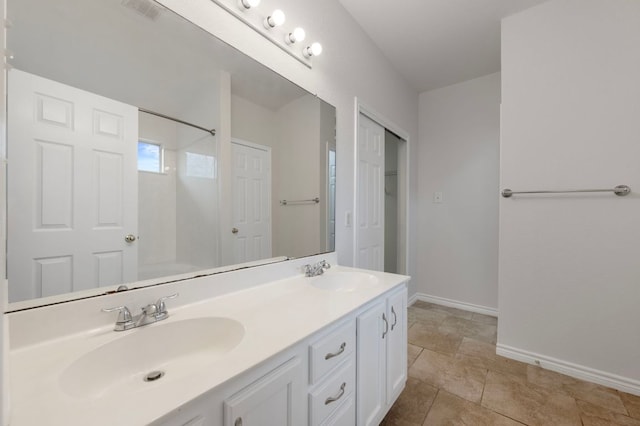 full bath with a sink, visible vents, baseboards, and double vanity