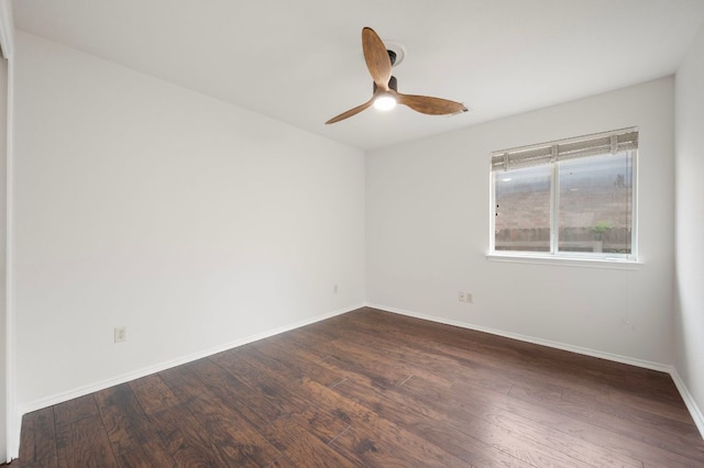 unfurnished room featuring baseboards, a ceiling fan, and dark wood finished floors