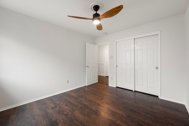 unfurnished bedroom featuring a closet, dark wood-style flooring, baseboards, and a ceiling fan