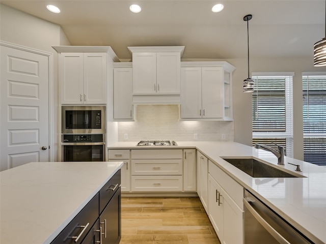 kitchen with recessed lighting, a sink, white cabinets, and appliances with stainless steel finishes