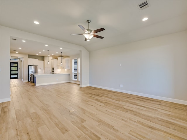 unfurnished living room with visible vents, ceiling fan, light wood-style flooring, and baseboards