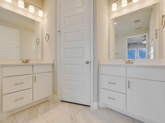 full bathroom with two vanities, visible vents, a ceiling fan, and marble finish floor