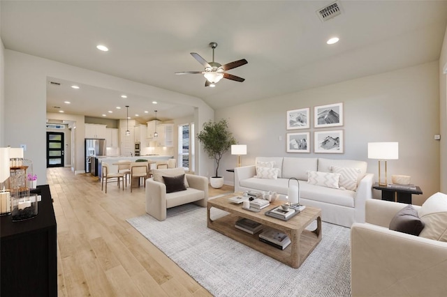 living room featuring light wood-style floors, a ceiling fan, visible vents, and recessed lighting