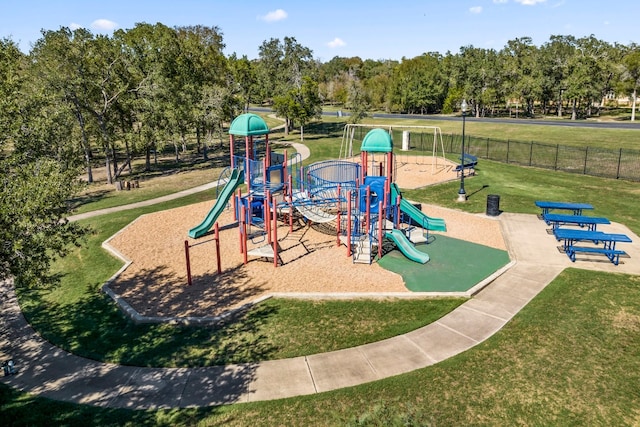 community play area with a yard and fence