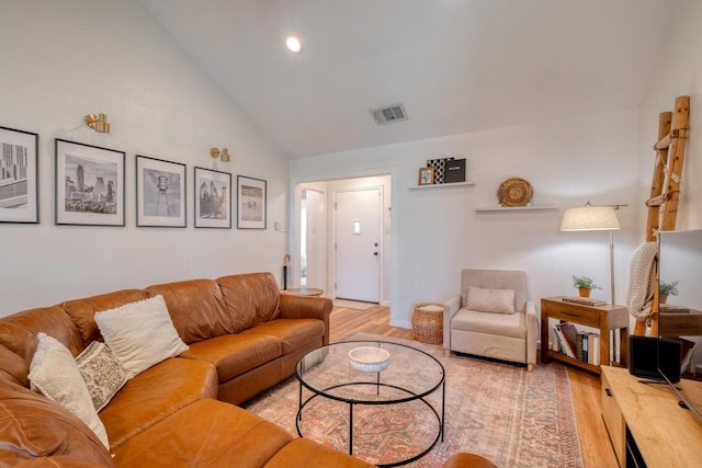 living room with visible vents, high vaulted ceiling, and light wood-type flooring