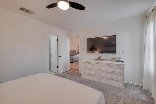 bedroom featuring light carpet, a ceiling fan, and visible vents
