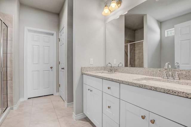 full bathroom featuring double vanity, tile patterned floors, a stall shower, and a sink