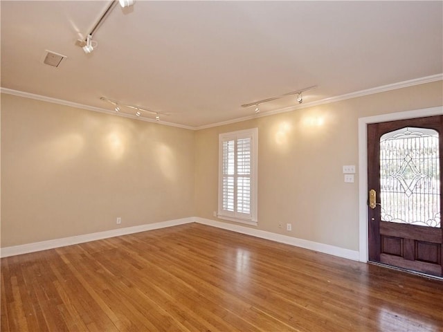 entrance foyer with track lighting, ornamental molding, wood finished floors, and baseboards