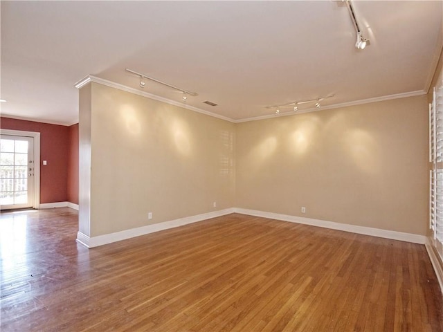 1621 Watchhill Rd, Austin, TX 78703 - spare room featuring rail lighting, wood finished floors, crown molding, and baseboards