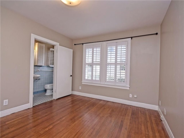 1621 Watchhill Rd, Austin, TX 78703 - unfurnished bedroom featuring wood finished floors, baseboards, and ensuite bathroom