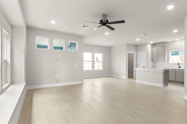 9708 Petrichor Blvd, Manor, TX 78653 - unfurnished living room featuring healthy amount of natural light, ceiling fan, recessed lighting, baseboards, and light wood-style flooring