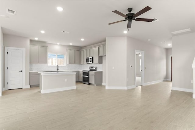 9708 Petrichor Blvd, Manor, TX 78653 - kitchen featuring gray cabinets, stainless steel appliances, a kitchen island, backsplash, and recessed lighting